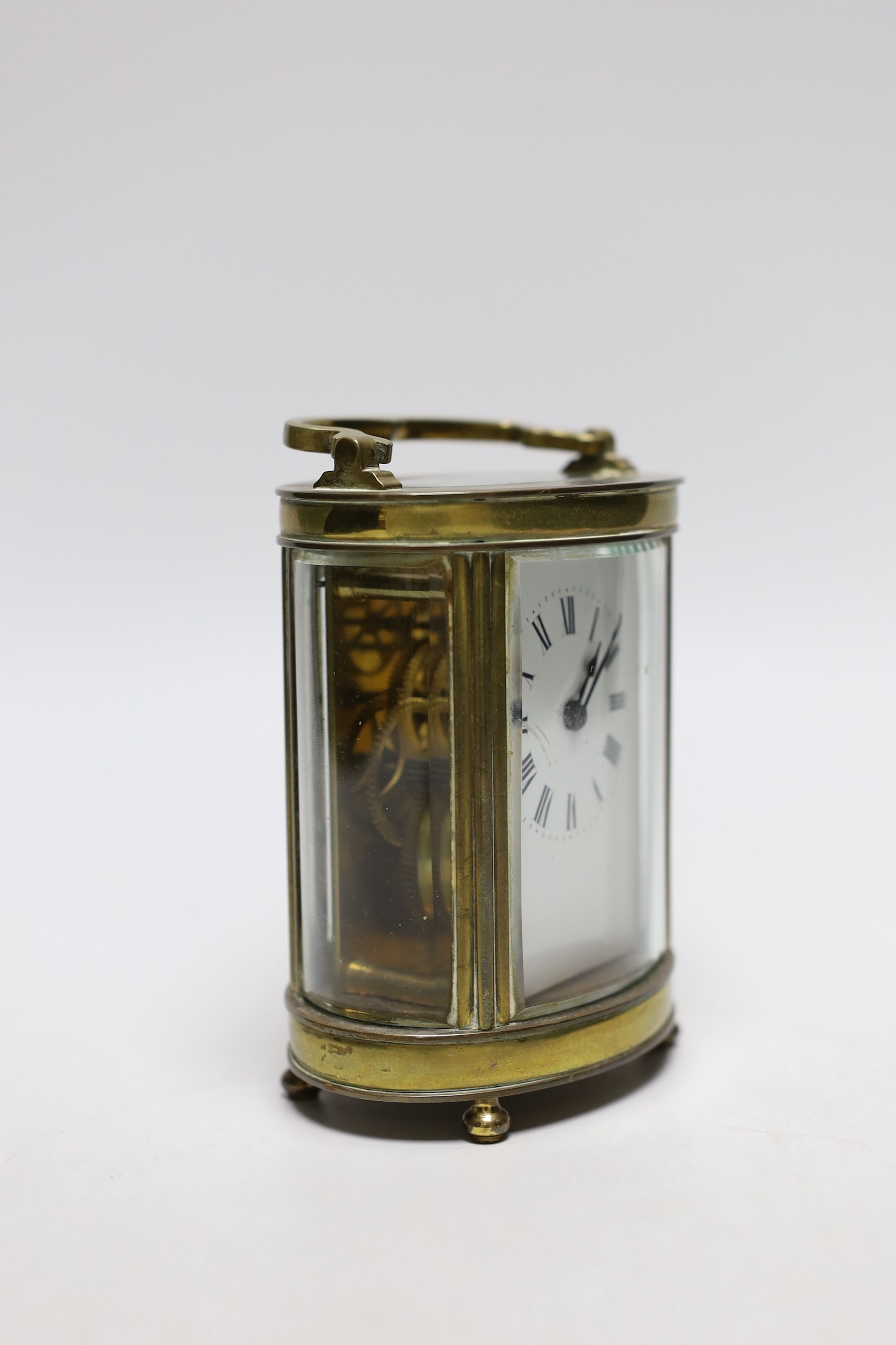 A French oval brass carriage timepiece, 11cms high